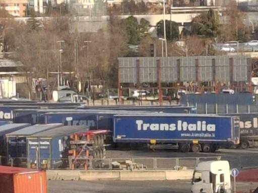 Varios trailers que tienen el texto TransItalia en letra blanca sobre fondo azul marino.